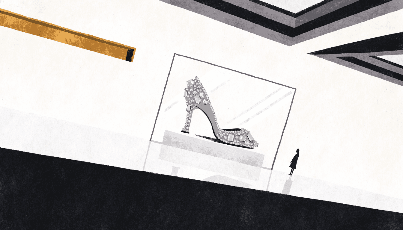 A crystal-covered high-heeled shoe displayed in a glass case on a department-store luxury floor